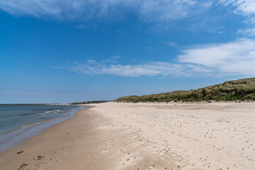 Fototapeta na wymiar beautiful white sand beach with high grassy sand dunes behind
