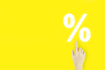 Business. Finance. Wealth. Young woman's hand pointing finger with hologram Interest rate on yellow...