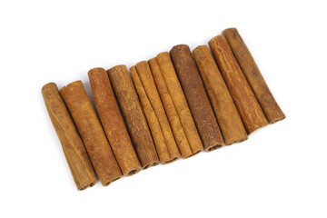 Line of cinnamon sticks isolated on white background. Close-up cinnamon sticks.