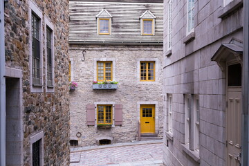 Fototapeta na wymiar View of narrow street lined with mid-18th Century stone houses leading to a 17th Century house on Sous-le-Fort street in the old town’s Petit-Champlain area, Quebec City, Quebec, Canada