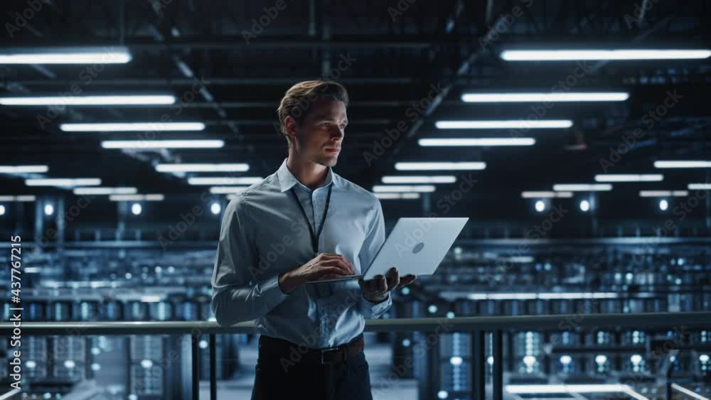 Leinwandbilder portrait of it specialist uses laptop in data center. server farm cloud computing facility with male