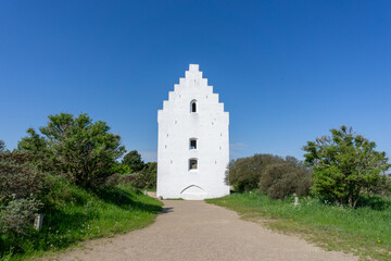 view of the Der Tilsandede Kirke church near Skagen buried in the sand dunes and vegetation