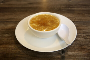 Egg drop soup AKA egg flower soup made of beaten eggs drizzled in homemade chicken broth with green onions. egg drop soup. egg flower soup. chinese food. Egg Flower Soup in a Chinese restaurant.