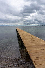 view of a long wooden pier leading out into clear ocean waters