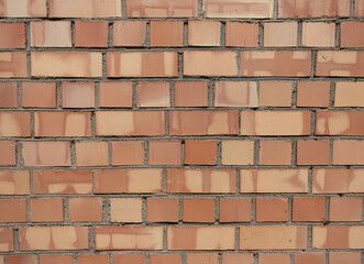 Fototapeta premium A piece of red textured brickwork. Natural look, with cracks, cement smudges, dirty spots.