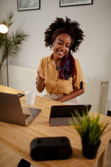 Smiling Afro American businesswoman modern office making gestures on a video call.