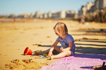 Еoddler girl having fun on the beach in Saint-Malo, Brittany, France