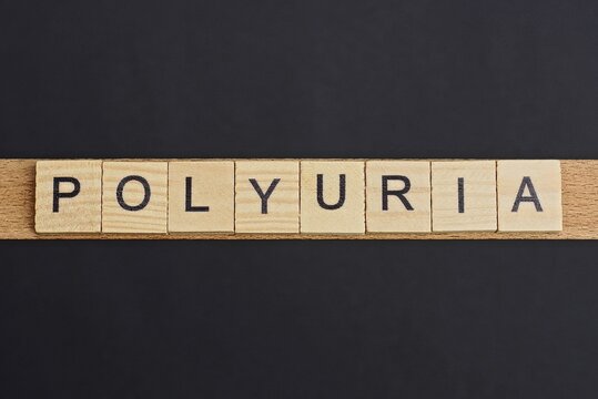 text on word polyuria from gray wooden letters on a black background