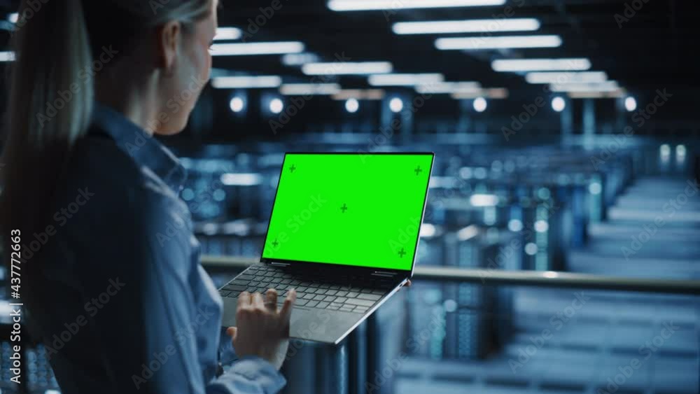 Poster Female It Specialist Using Chroma Key Laptop in Data Center. Big Server Farm Cloud Computing Facility with Maintenance Engineer Working with Green Screen Computer. Medium over the shoulder Shot