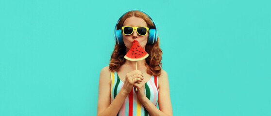 Summer fashion portrait of young woman in headphones listening to music with juicy slice of...