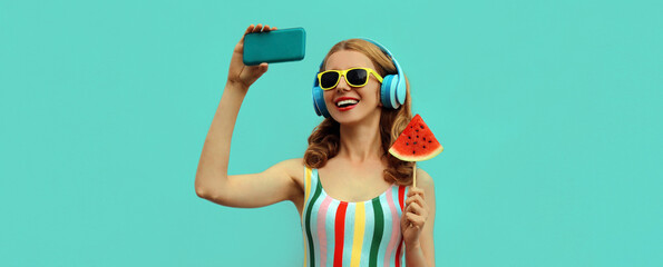 Summer portrait of cheerful happy laughing young woman taking a selfie by smartphone in headphones...