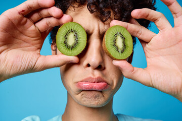 man with curly hair holding kiwi near class face closeup emotions