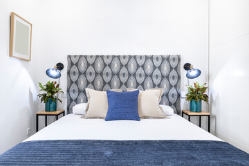 Frontal image of a double bedroom with different shades of blue