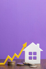 Real estate market, graph, up arrow. House construction model and a stack of coins. The concept of...