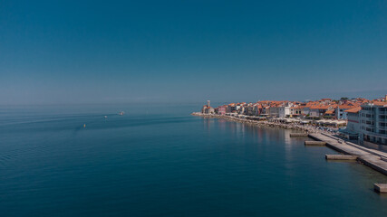 Naklejka na ściany i meble Aerial panorama of picturesque city of Piran at the heart of Slovenian istria on a sunny day. Calm sea and blue skies.
