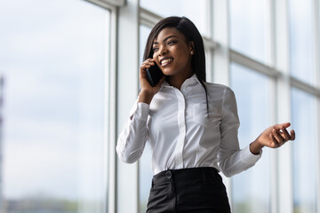 attractive african american office worker talking on the phone in office