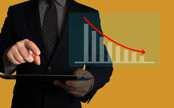 Businessman pointing at a chart on his tablet. Chart illustrating decreasing cost, downtimes, levels of waste,  customer dissatisfaction, number of complaints or order cancellations.