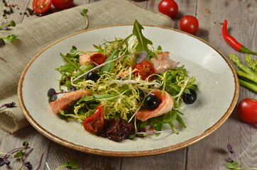 Warm Salad with Grilled Salmon and Vegetables on rustic table