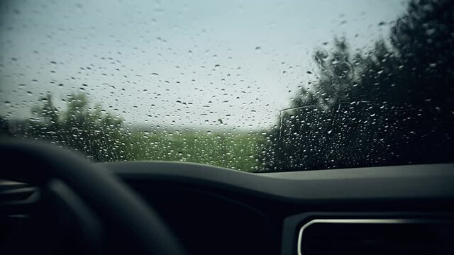 Rain drops on the windshield of a car on a rainy day