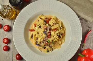 Pasta Fettuccine with tomato and cheese in white bowl. on wooden rustic background top view