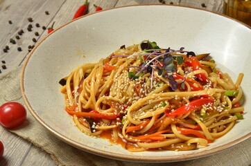Delicious freshly cooked meat wok on white plate with ingredients on background