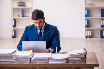 Young businessman employee unhappy with excessive work in the office