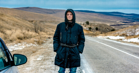 A man in warm clothes votes on the road in cold weather