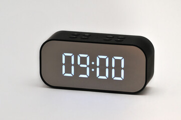 Electronic clock with digital indication of time and date on a white background