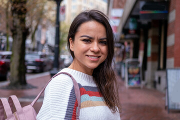 カナダの街中でリュックサックを持って散策するメキシコ人女性