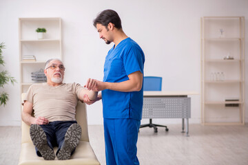 Obraz premium Old male patient visting young male doctor