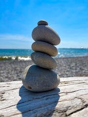 Fototapeta premium Cairn of Beach Pebbles on Driftwood