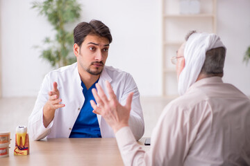 Old male patient visiting young male doctor dentist