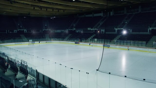 Empty Professional Ice Hockey Rink Arena with Lights Turning On. Big Stadium Ready for the Championship to Begin. High Quality Venue Ready to Fit Thousands of Fans Enjoy the Game. Establishing Shot