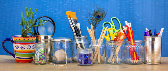 Recycled jars, tin and mug reused for different contents on wooden bench,  recycling at home for sustainable living, save money and zero waste