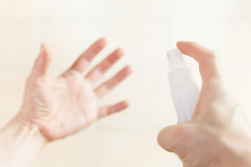 man using hand sanitizer spray