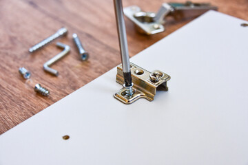 Assembly of cabinet furniture. screwdriver, screws, furniture fittings, door hinges. self-assembly of furniture