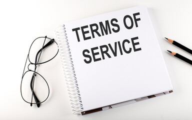 Notepad with text TERMS OF SERVICE . White background. Business