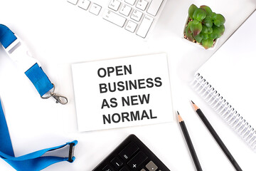 OPEN BUSINESS AS NEW NORMAL Words on the card with keyboard and office tools