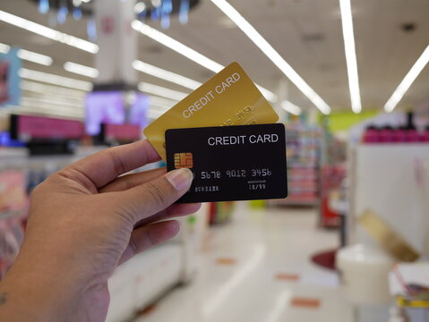 hand holding creadit card with blurred supermarket background.
