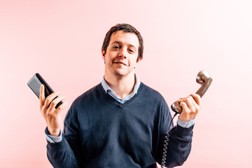 young adult man of thirty-five years in shirt and blue v-neck sweater with pink background with...