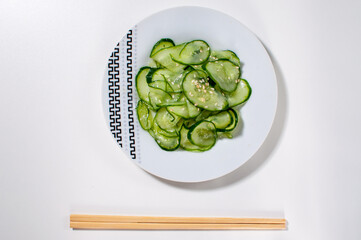 White plate with japanese sunomono salad on a white table or background. Top view.