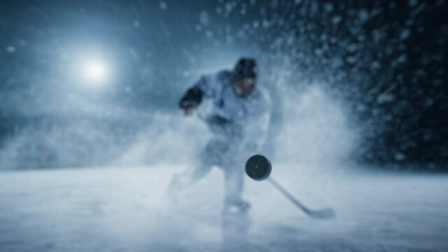 Ice Hockey Rink Arena: Professional Player Shooting, Hitting, Stricking the Puck with Hockey Sticks. Athlete Scoring a Goal. Dramatic Mock-up. Wide Shot, Cinematic Lighting, Slow Motion