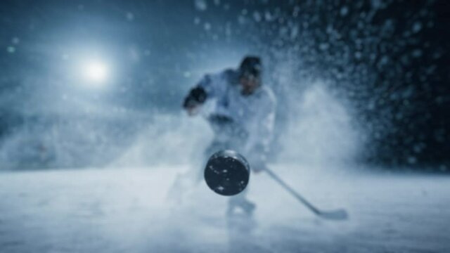 Ice Hockey Rink Arena: Professional Player Shooting, Hitting, Stricking the Puck with Hockey Sticks. Athlete Scoring a Goal. Dramatic Wide Shot, Cinematic Lighting, 3D Puck Flying in Slow Motion