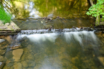 Long exposure of water cascading over a weir in a creek