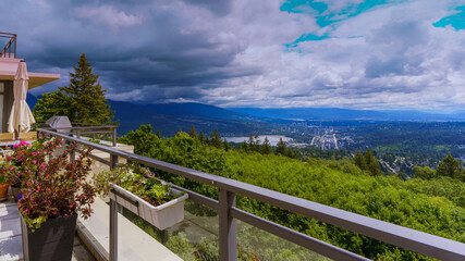 Ominous clouds advancing across Fraser Valley and town of Port Moody as viewed from Burnaby Mountain