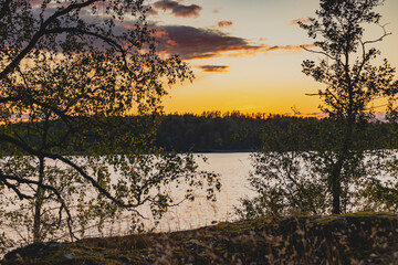 Fototapeta na wymiar Sunset on a lake with rocky shores in Karelia