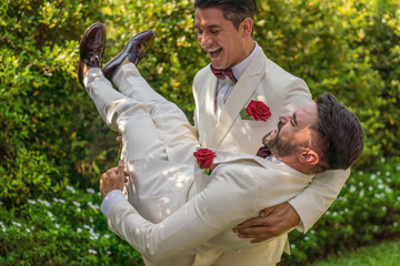 LGBTQ gay couple having fun together in garden in wedding ceremony