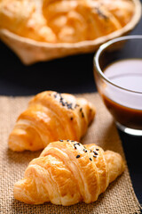 French croissant with black sesame seeds and coffee cup, morning breakfast