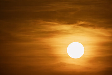 large round orange sunrise or sunset with texture of cloudy sky for background , big and powerful sun shot with super telephoto lens