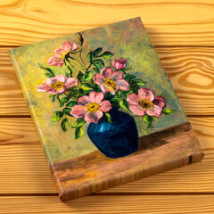 Framed canvas print of vintage oil painting of flowers in vase isolated on a wooden background....
